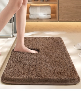 Macro shot of soft brown shaggy bathroom mat texture with a foot for comfort display