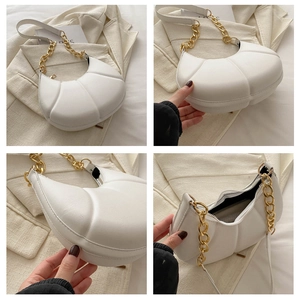Detail view of white pleated crescent bag with gold chain and interior structure