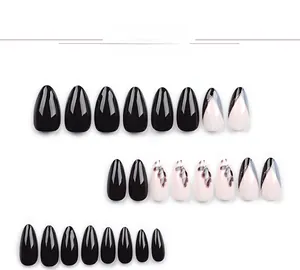 Vue détaillée d'ongles amande noirs avec des motifs minimalistes de feuilles de plantes