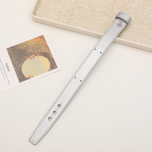 Detail of silver faux leather wrist strap with adjustable holes and metal buckle