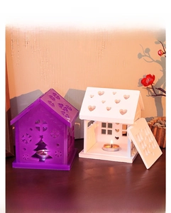Detail showing house-shaped resin candle holders with heart and Christmas tree cutouts