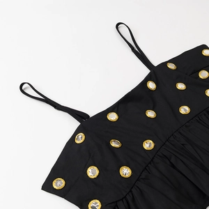 Gros plan détaillé des bretelles avec sequins argentés à bord doré sur tissu noir élégant