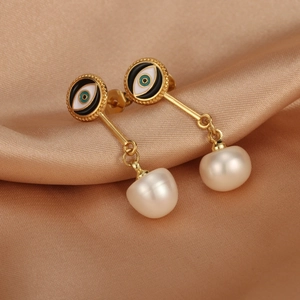Close-up of 18K gold earrings with evil eye enamel and freshwater pearls on silk
