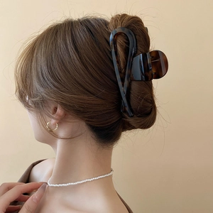 Detail view of large tortoiseshell leopard print hair claw clip on long hair