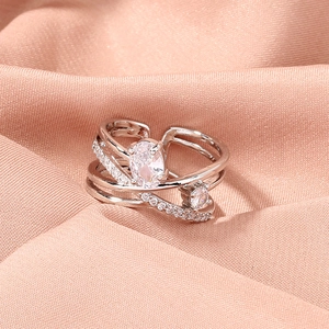 Detail of silver multilayer ring with oval zircon and pavé crystals on silk background