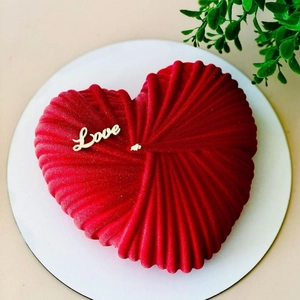 Vue détaillée de dessus d'un gâteau mousse cœur rouge avec décoration Love dorée