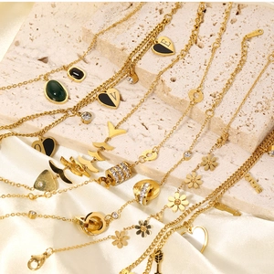 Detail showing 18K gold chain with black enamel heart pendant and zircon elements