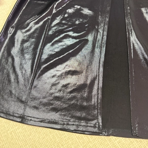 Detail von schwarzem Metallic-Stoff mit Seitenschlitz und robuster Doppelnaht