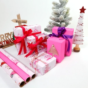 Pink Christmas gift wrapping paper roll with festive Santa Claus and reindeer patterns