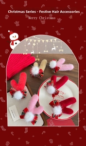 Détail de pinces à cheveux de Noël avec nœuds écossais rouges et pompons en peluche