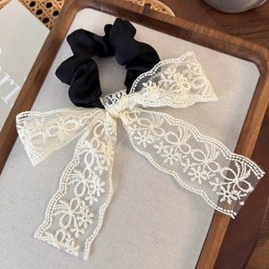 French vintage white lace bow hair scrunchie on a decorative wooden tray with warm lighting