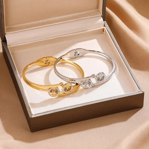 Detailed view of Tree of Life engraving and micro-pave crystals on gold and silver bangles