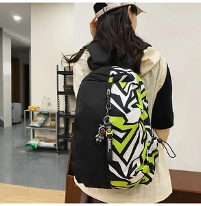 Close-up of trendy nylon backpack with geometric color-block design and astronaut charm