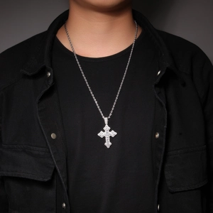 Gros plan d'un pendentif croix en zircon argenté sur une chaîne torsadée pour homme