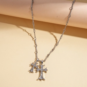 Detail of silver double cross pendants with sparkling rhinestones on a metal chain