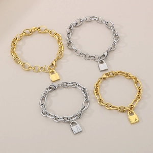 Close-up of gold and silver cuban link bracelets with minimalist padlock charms
