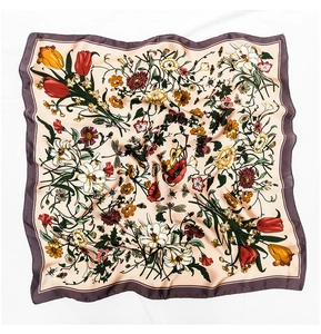 Detailed macro view of vintage floral and insect print on silky pink square scarf