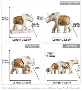 Detail view of white resin elephant sculptures with golden leaf patterns and dimensions