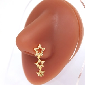 Clou de nez doré avec trois pendentifs en forme d'étoile scintillante sur modèle réaliste