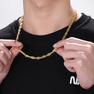 Détail d'une chaîne corde de 6mm en acier inoxydable doré portée par un mannequin homme