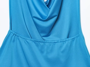 Detailed close-up of blue fabric showing elegant draped neckline and stitching craft
