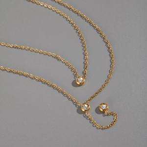 Close-up of golden stainless steel necklaces with sparkling zircon inlaid pendants