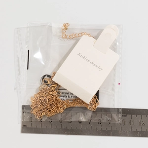 Detailed size measurement of a gold pearl tassel necklace with white paper card packaging