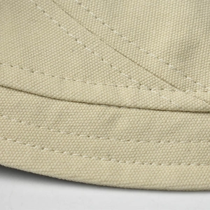 Detail of beige cotton bucket hat showing durable canvas texture and reinforced stitching