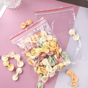 Transparent PE zip-lock bags for food storage filled with colorful bow-tie pasta noodles.