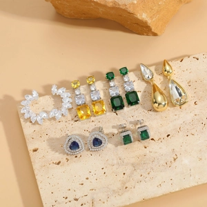 Detailed collection of elegant zircon drop earrings in various gemstone colors on stone tray
