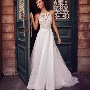 Elegant sleeveless halter wedding dress with intricate lace embroidery and tulle skirt
