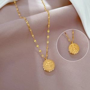 Dettaglio della collana in acciaio al titanio dorato con pendente bifacciale Fu e Xi