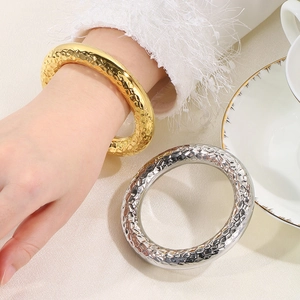 Detail of 18k gold and silver hammered texture open bangles with polished finish
