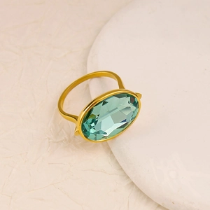Macro detail of oval blue sapphire gemstone set in a gold stainless steel band