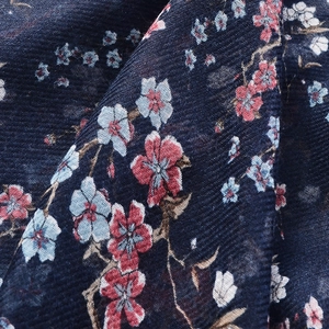 Detailed macro view showing the twill weave and floral print texture of the navy blue scarf
