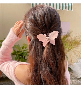 Pink frosted butterfly hair claw clip shown securing a half-up hairstyle on a model