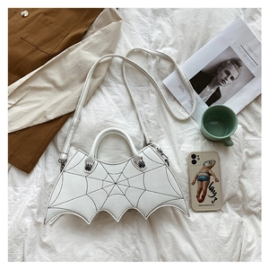 Detail of white bat-shaped PU leather bag with black spider web stitching and metal bat hardware