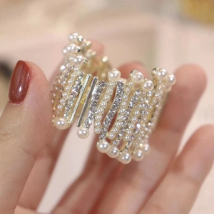 Detailed close-up of high ponytail shark clip with pearls and sparkling rhinestones