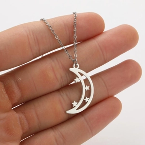 Macro detail of silver moon and stars pendant necklace with polished hollow design
