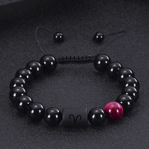 Macro shot of Aries zodiac bead on adjustable black onyx and tiger eye beaded bracelet