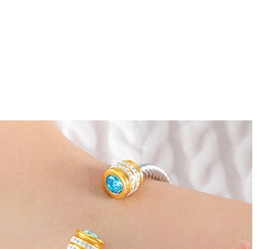 Détail de la pierre bleue et pavé blanc sur bijoux bicolores en or et argent poli
