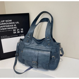 Close-up of Morandi blue leather handbag with textured finish and buckle pocket detail