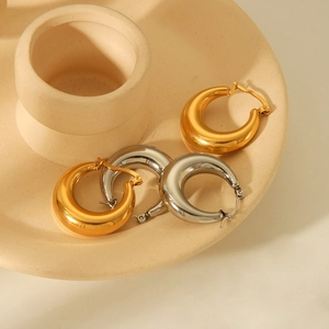 Minimalist thick hollow geometric gold and silver stainless steel hoops on ceramic tray