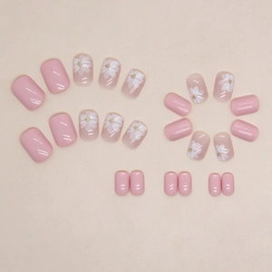 Unghie finte rosa con fiori bianchi e glitter dorati in forma quadrata corta