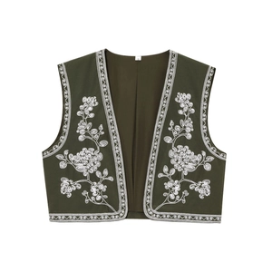 Gros plan du gilet vert olive avec broderie florale blanche délicate et texture de qualité