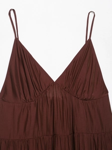 Close-up of chocolate brown layered dress with spaghetti straps and pleated V-neck details