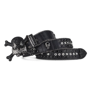 Detail of black crocodile texture belt with skull buckle and black rhinestone inlay