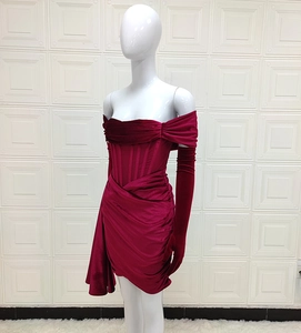 Détail d'une robe de soirée en velours bordeaux avec gants longs et design froncé chic