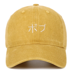 Gros plan sur une casquette en coton délavé jaune avec broderie japonaise blanche