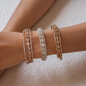 Three-layer zircon bangles in gold, rose gold, and silver finishes on a model's wrist